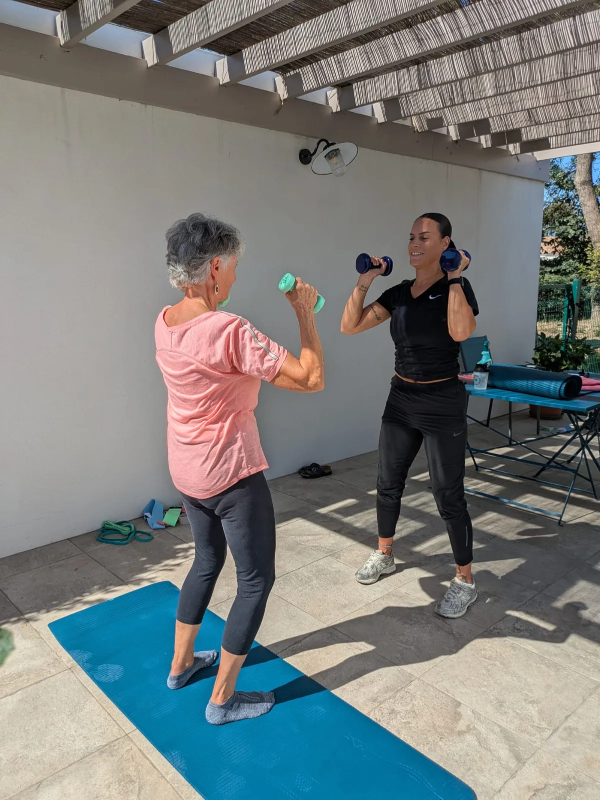 Charlotte, coach sportif pour femmes à La Rochelle, en séance de renforcement musculaire avec haltères au domicile d'une cliente